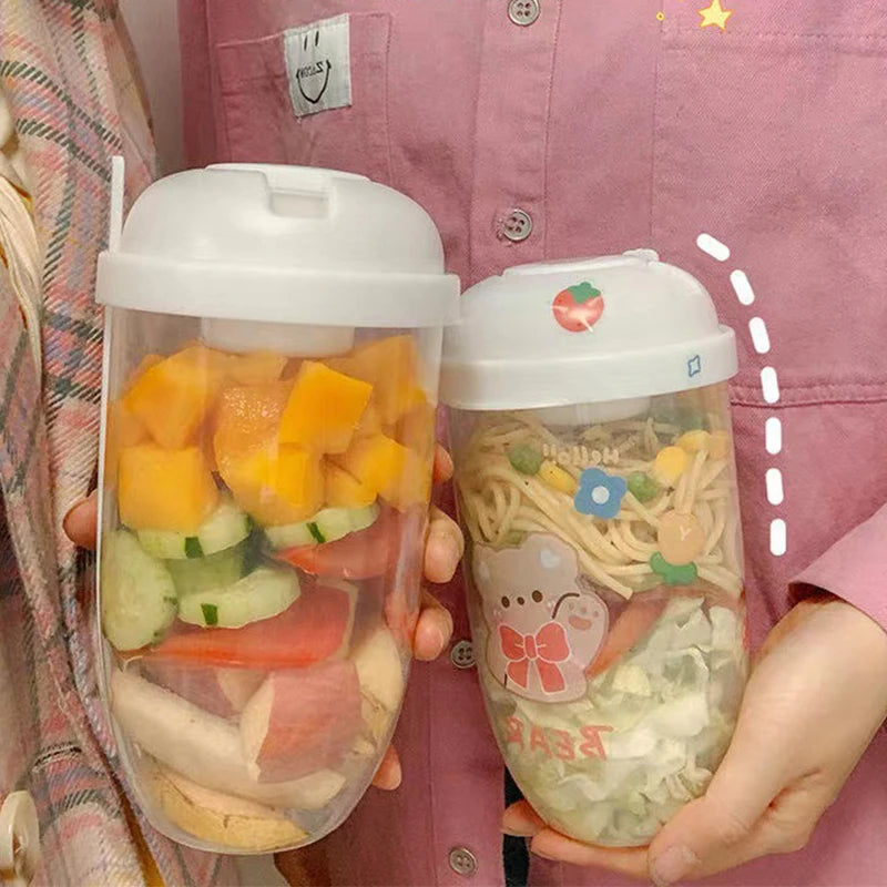Two clear containers with food held by a person wearing a pink shirt.