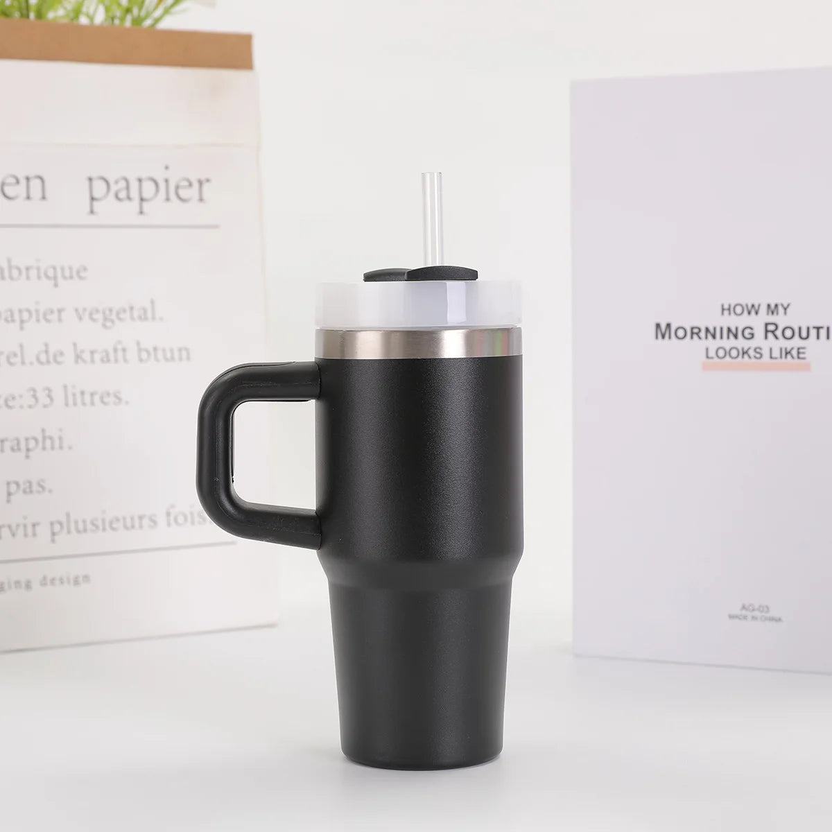Black insulated travel mug with a handle on a white surface