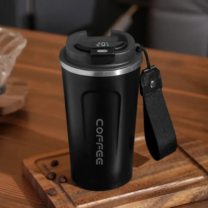 Black coffee mug with digital temperature display on a wooden surface