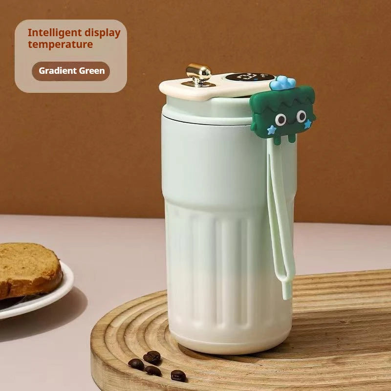 White thermos with green accents on a wooden coaster, with a brown background.