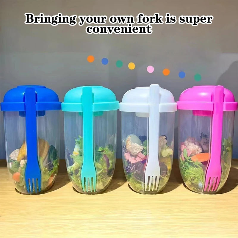 Four colorful containers with built-in forks, each containing a salad, on a wooden surface.