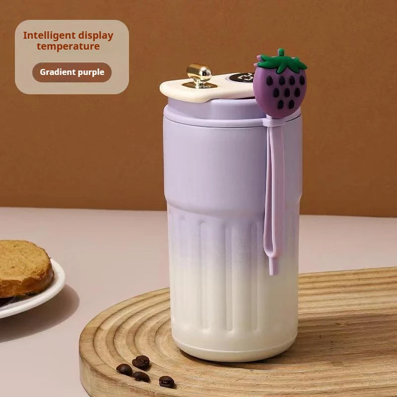Gradient purple tumbler with a small plant design on a wooden surface.