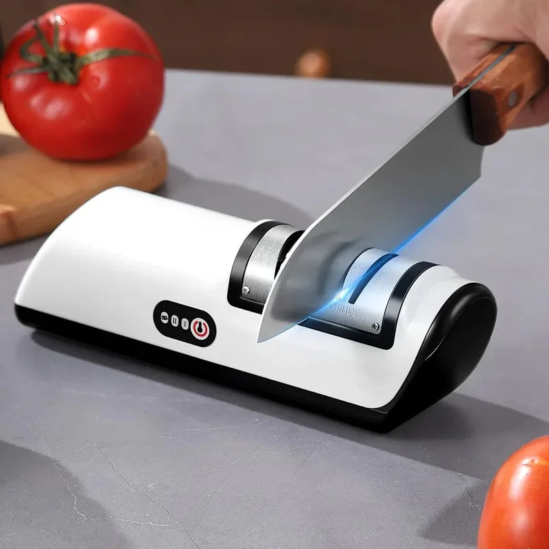 Knife being sharpened on a white knife sharpener with tomatoes in the background