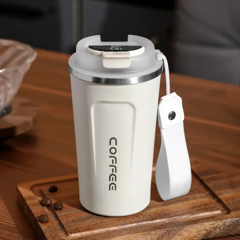 White insulated coffee mug with digital display on a wooden surface