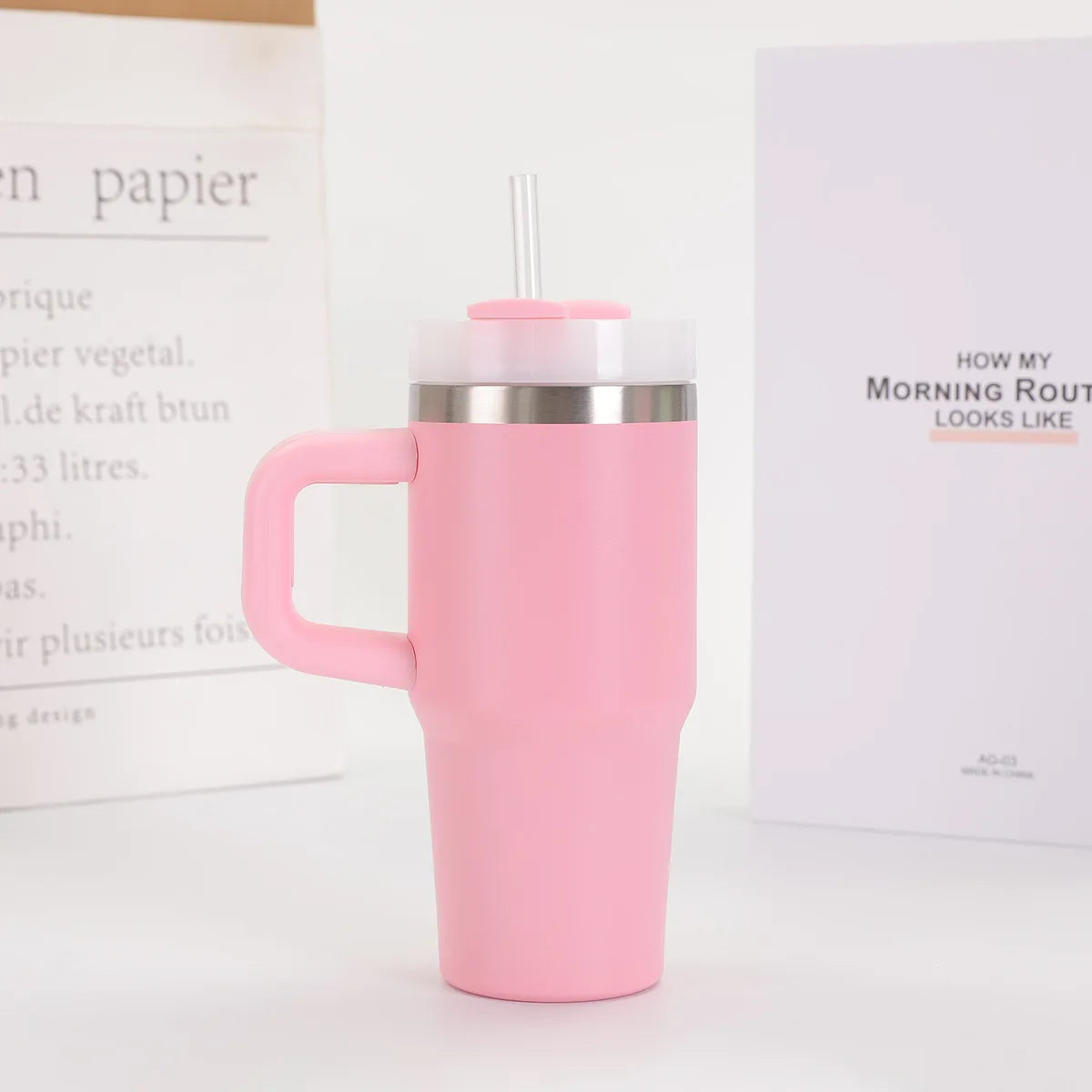 Pink insulated mug with handle on a white surface