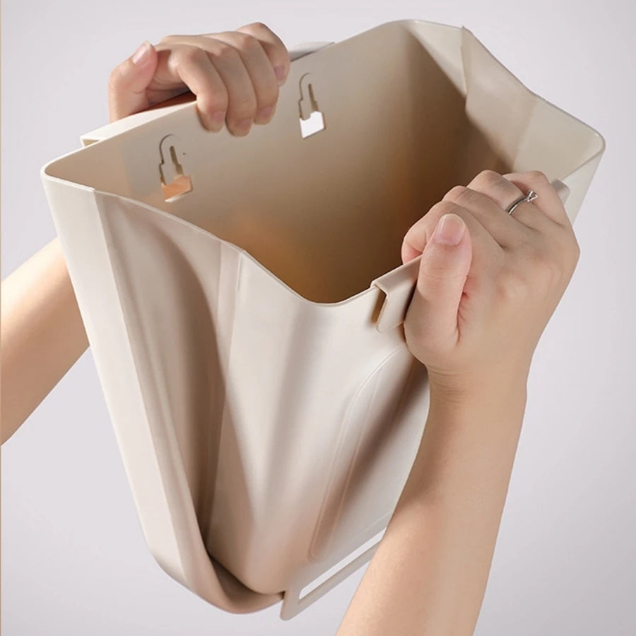 Beige handbag held by a person against a light gray background