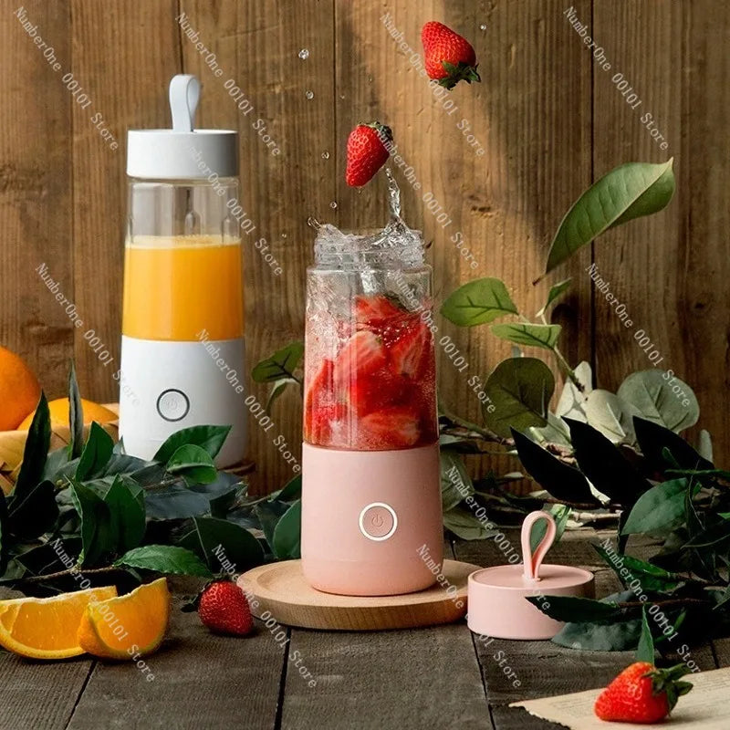 Pink portable blender with strawberries and oranges on a wooden surface with greenery.