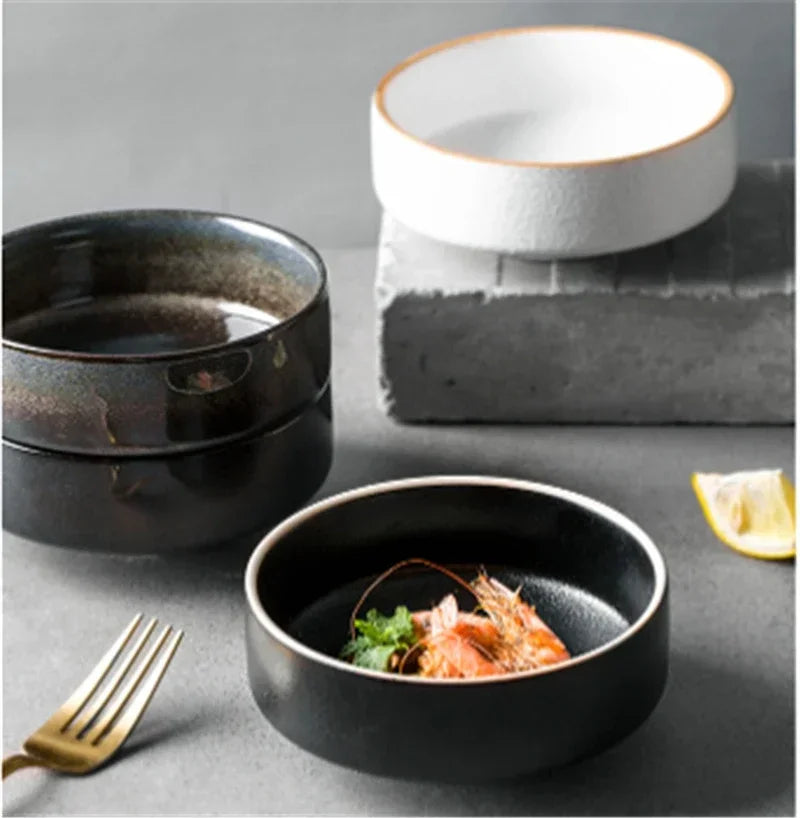 Three ceramic bowls on a gray surface with a dish of food and a lemon wedge.