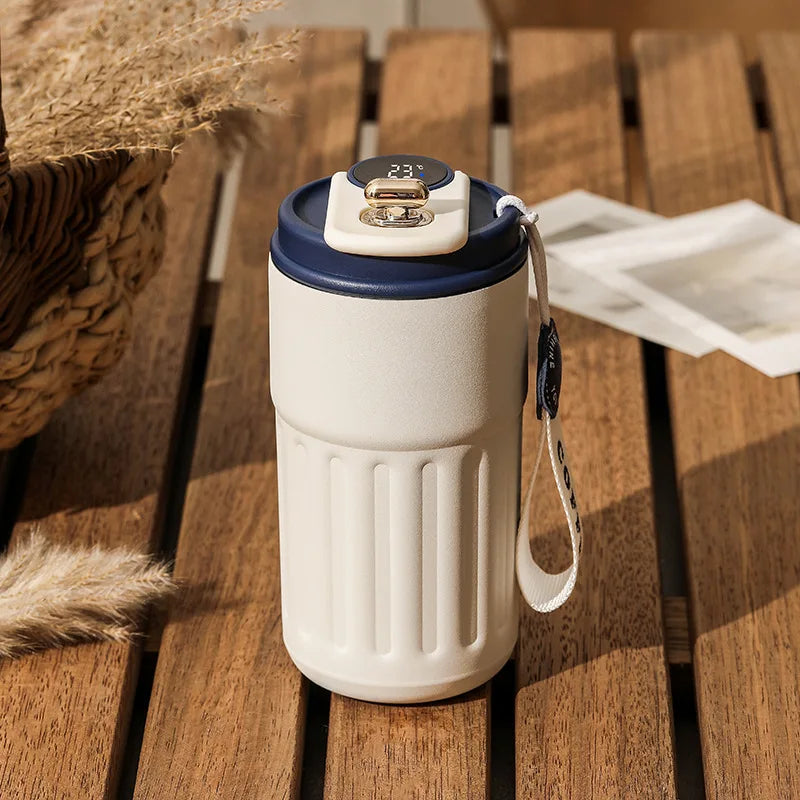 White and navy blue insulated coffee cup with a lid on a wooden surface