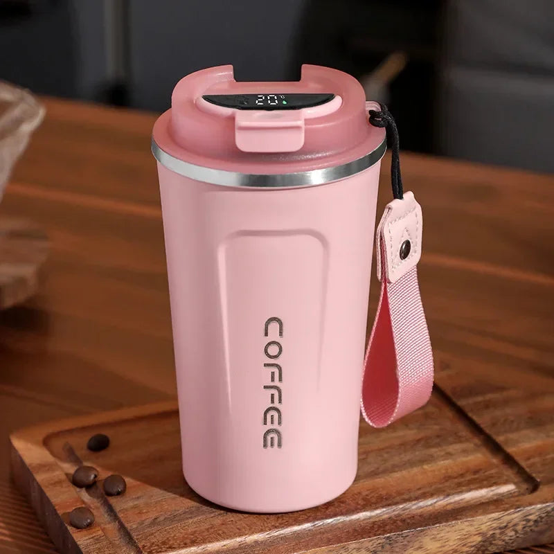 Pink coffee tumbler with digital temperature display on a wooden surface