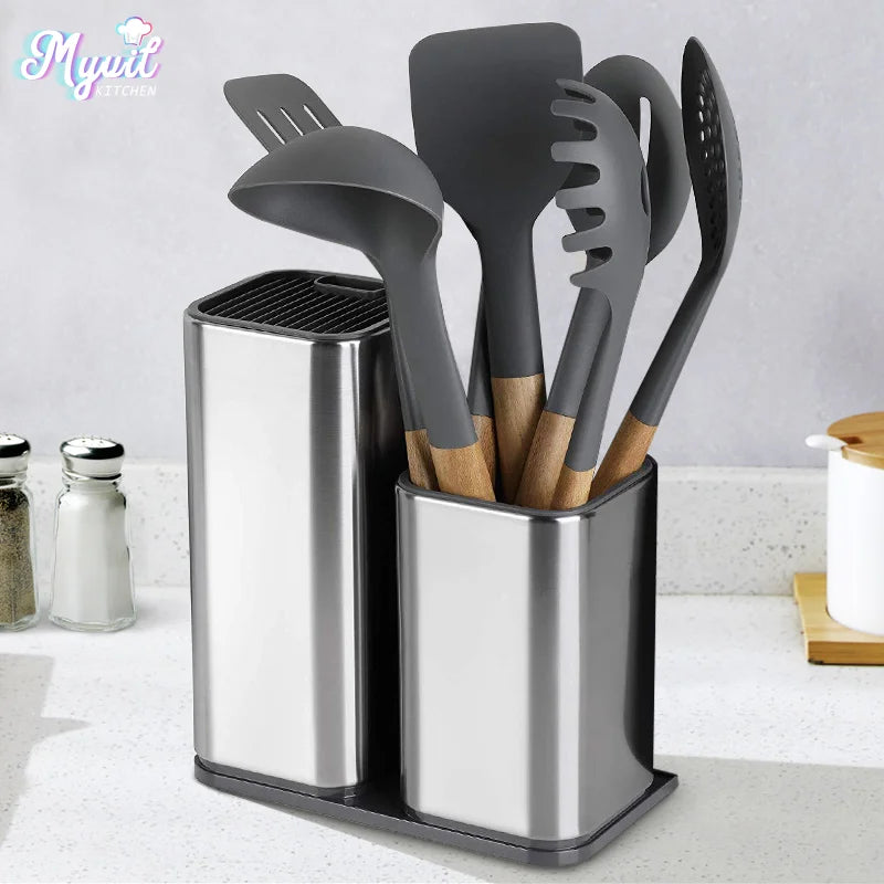 Set of kitchen utensils in a silver holder on a kitchen counter.
