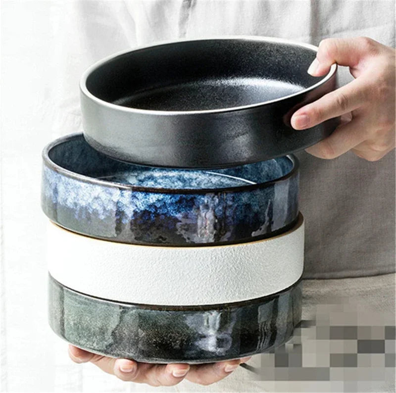 Stack of ceramic bowls with gradient design held by a person