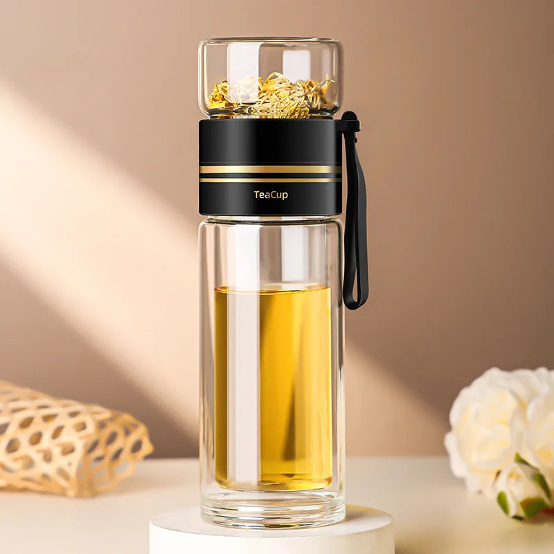 Glass tea infuser bottle with black lid on a beige background