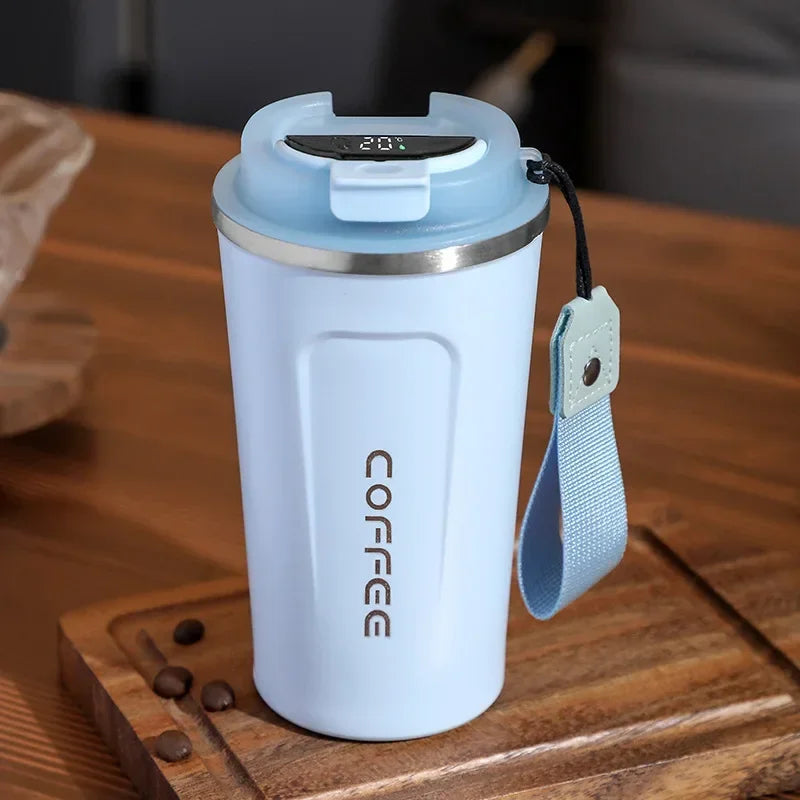 Light blue coffee tumbler with digital display on a wooden surface